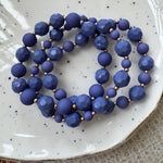 Blue beaded bracelets on a white speckled plate