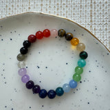 Multicolored beaded bracelet on a white plate with a textured background
