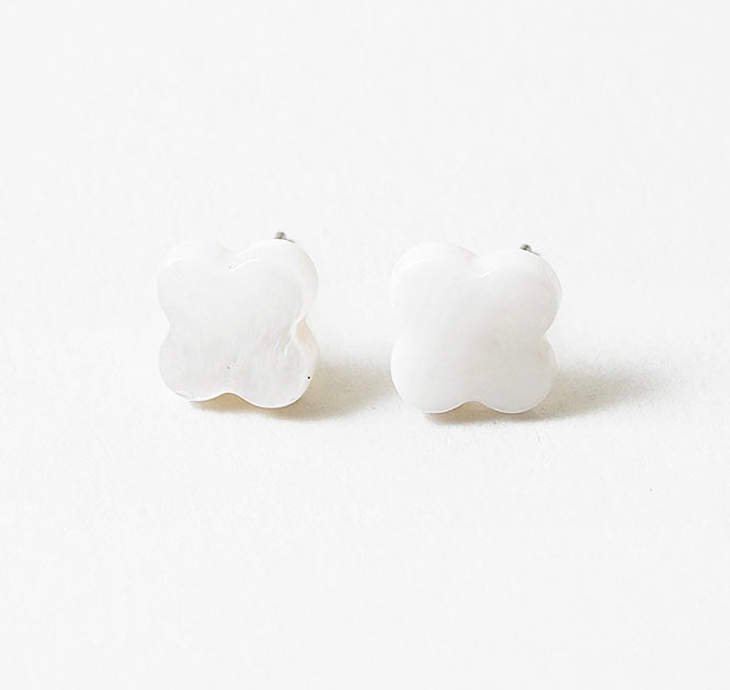White stud earrings in the shape of rounded crosses.