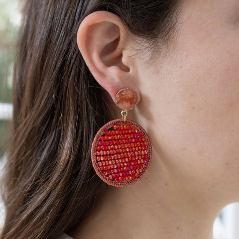 Picture of model wearing amber druzy studs with dangling red beaded discs.