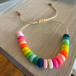Picture of a cord bracelet with brightly colored resin beads in blue, greens, yellow, orange, pinks and white.