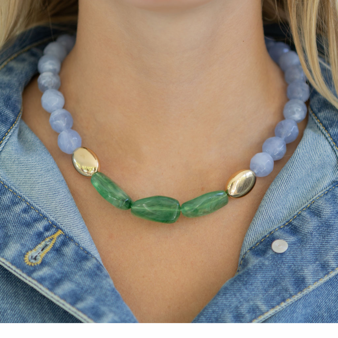 Necklace with green and gold accents worn by a person, displayed on a smartphone screen.
