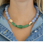 Necklace with green and gold accents worn by a person, displayed on a smartphone screen.