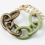 Bracelet with large gold and green chain links on a white background