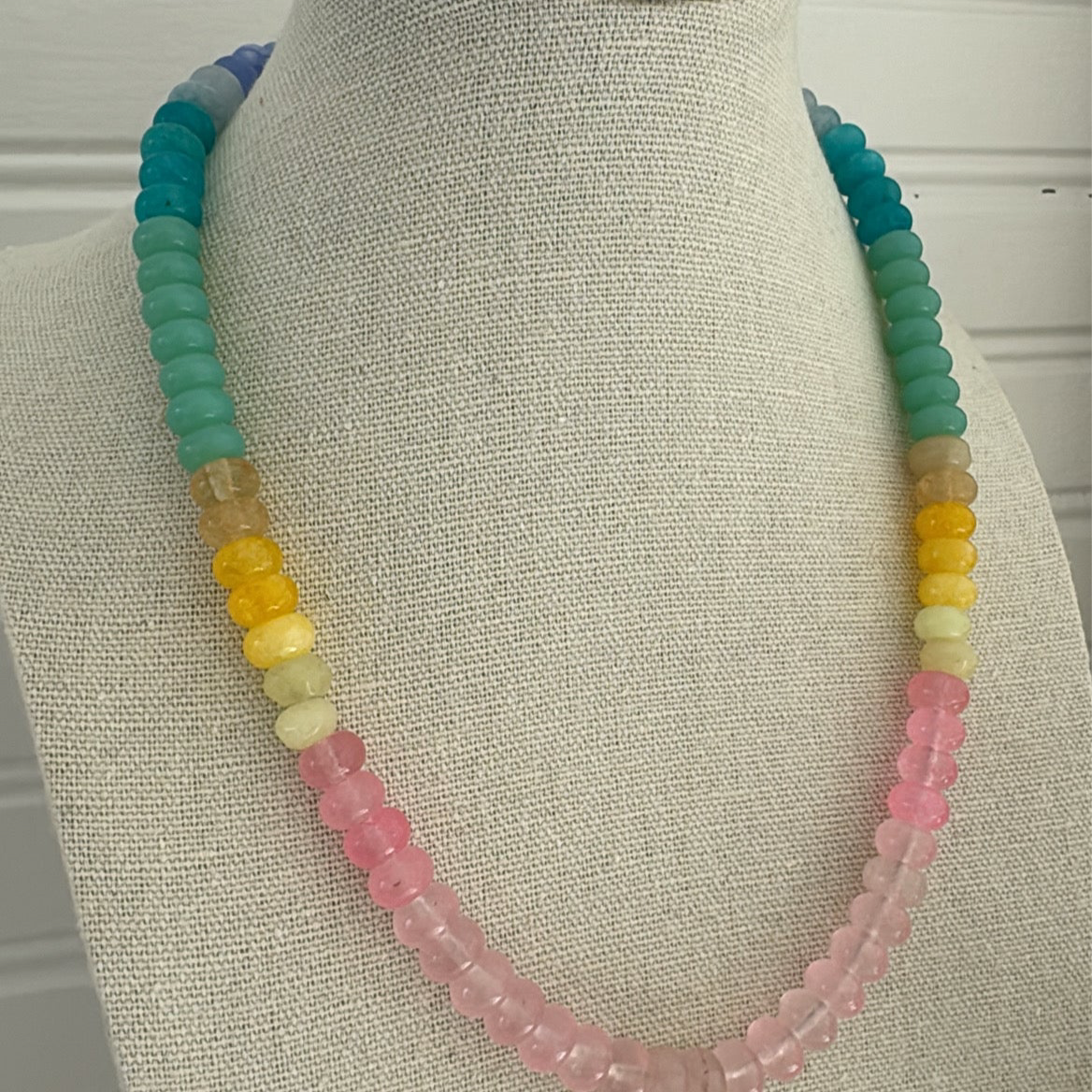Picture of a resin bead necklace in blues, teals, yellows and pinks.