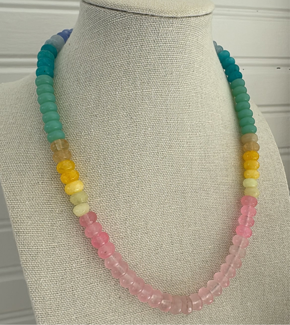 Picture of a resin bead necklace in blues, teals, yellows and pinks.