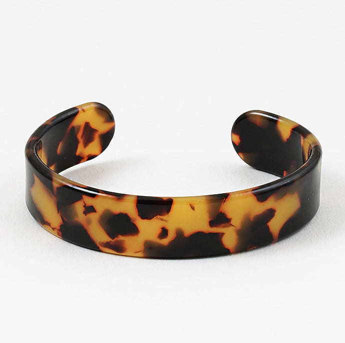 Tortoiseshell patterned cuff bracelet on a white background