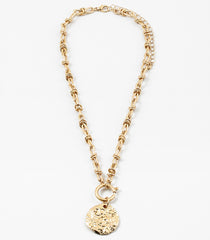 Gold toggle chain necklace with a large hammered disc pendant.