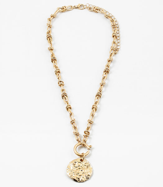 Gold toggle chain necklace with a large hammered disc pendant.