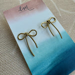 Earring holder displaying fine gold bow earrings