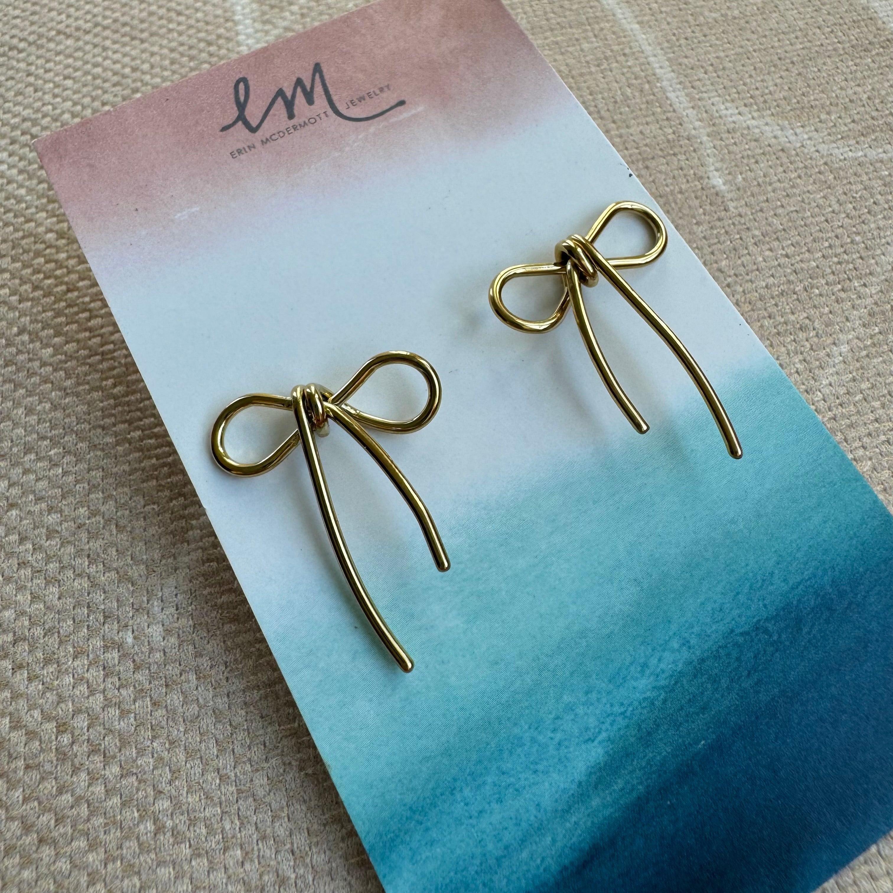 Earring holder displaying fine gold bow earrings
