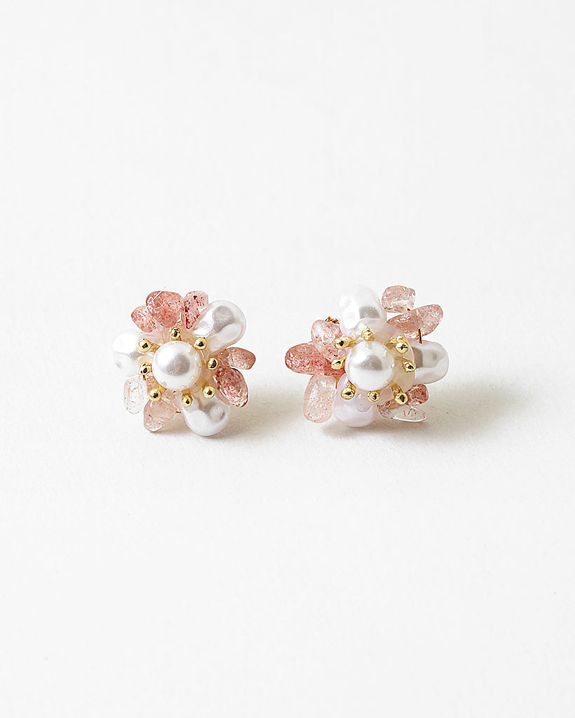 A pair of gold-colored earrings adorned with white pearls and pink accents.