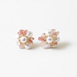 A pair of gold-colored earrings adorned with white pearls and pink accents.