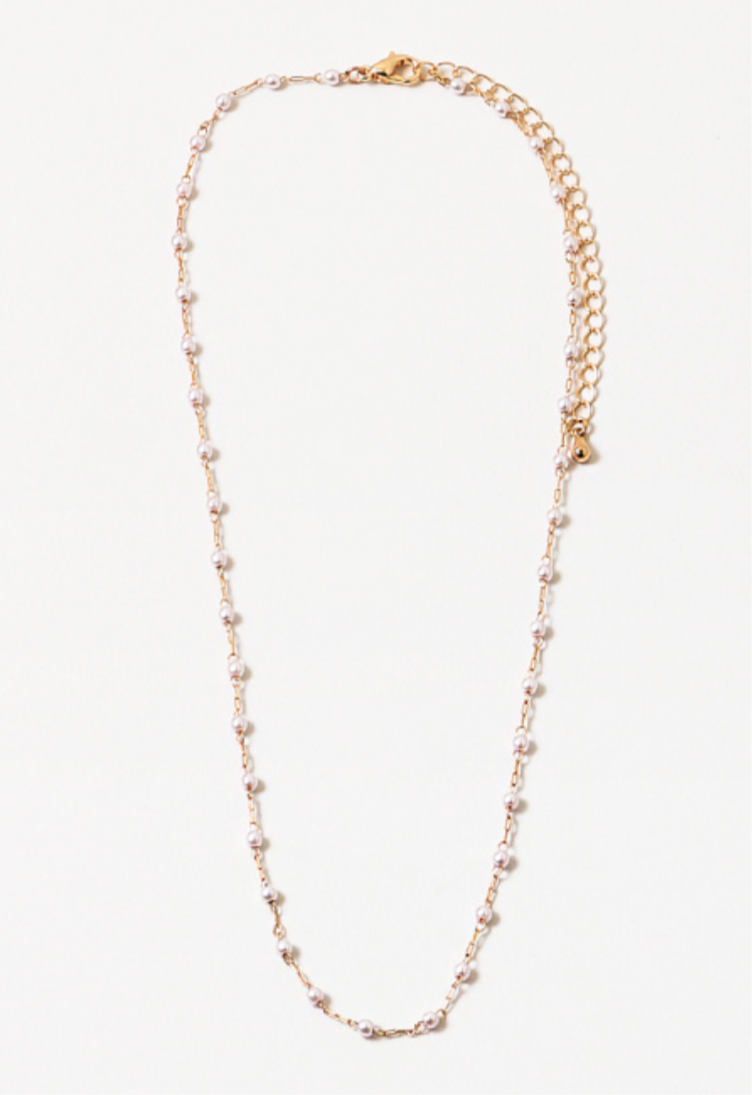 A necklace with small pearls and gold delicate chain links, with an extender chain, displayed against a white background.