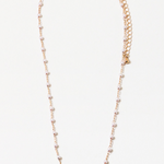 A necklace with small pearls and gold delicate chain links, with an extender chain, displayed against a white background.