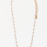 A necklace with small pearls and gold delicate chain links, with an extender chain, displayed against a white background.