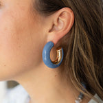 Model wearing chunk gold hoop earring with blue accent