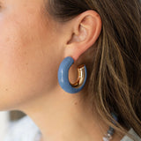 Model wearing chunk gold hoop earring with blue accent