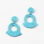 Large turquoise beaded statement earrings on a white background