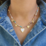 Bead necklace in blues, whites, beige and 4 gold heart pendants and white enamel heart pendant.