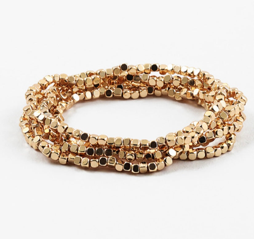 A set of gold-colored square stretch bracelets displayed against a white background.
