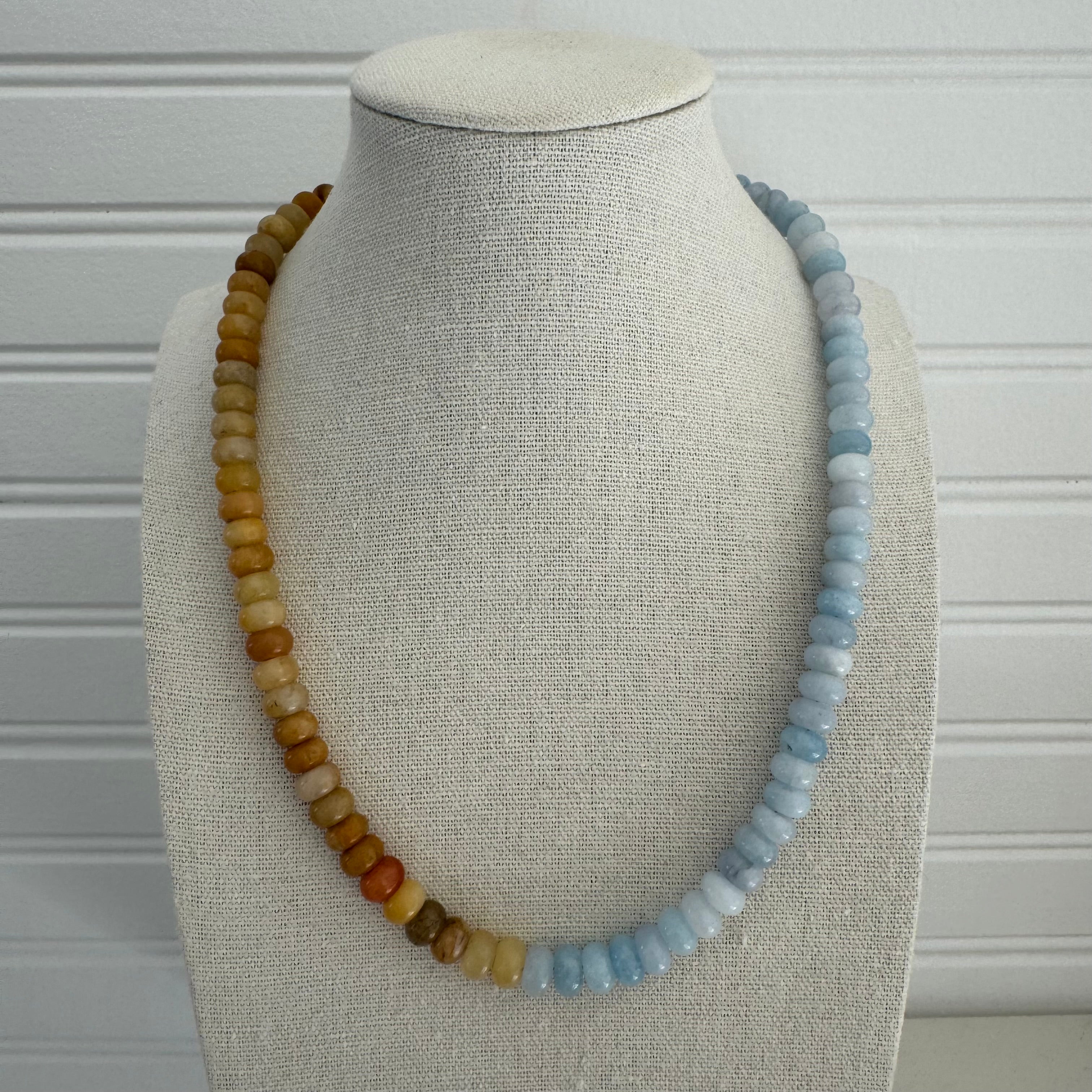 Picture of a bead necklace that is half amber yellow and half light blue.