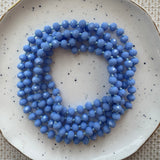 Blue beaded necklace on a speckled ceramic plate