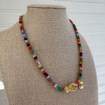 Picture of a multicolor bead necklace with a large fish pendant at the center.