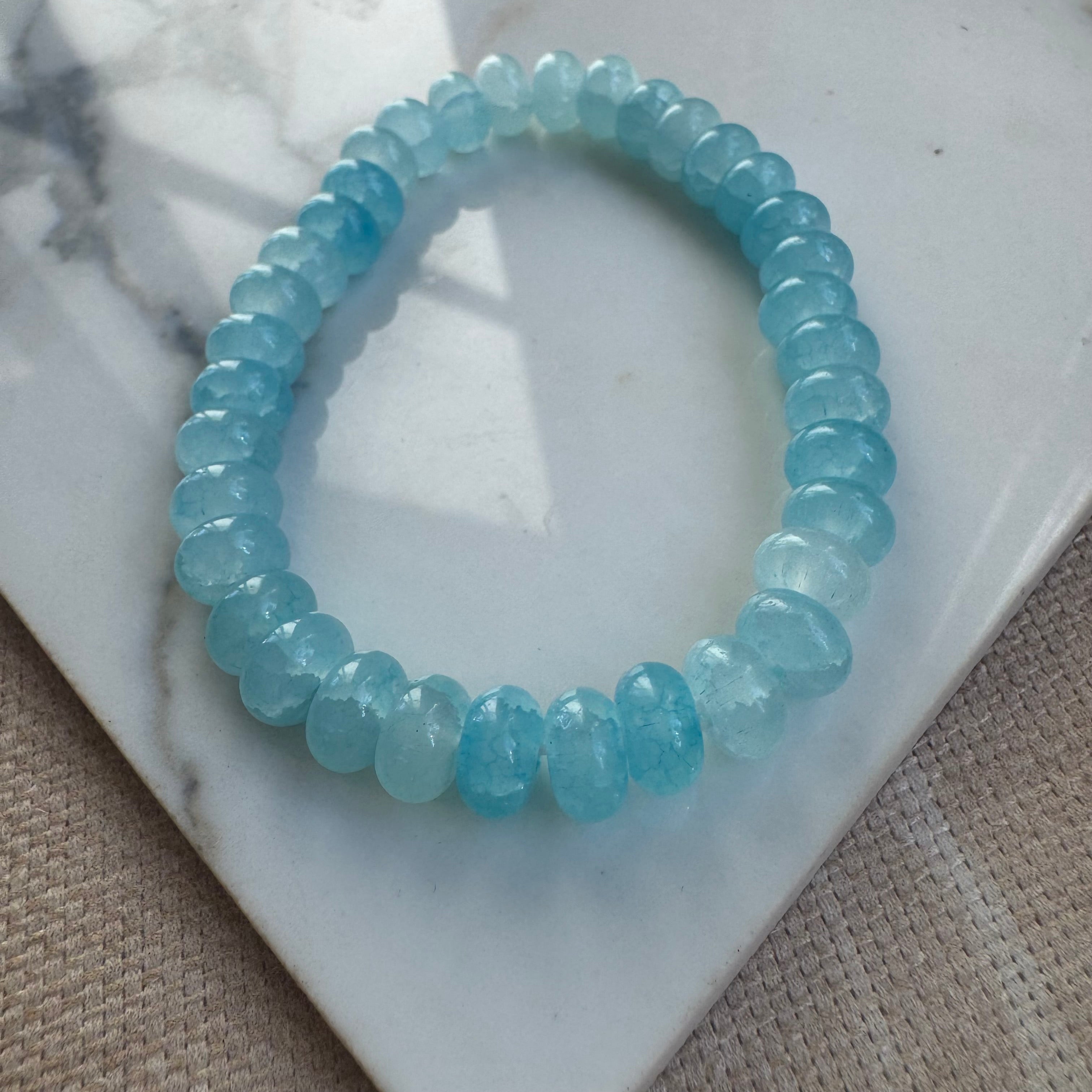 Blue beaded bracelet on a marble surface
