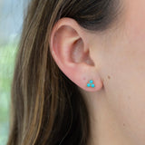 Picture of a model's ear displaying a three stone turquoise stone stud earrings.