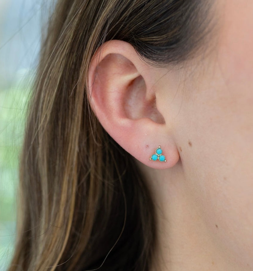 Picture of a model's ear displaying a three stone turquoise stone stud earrings.
