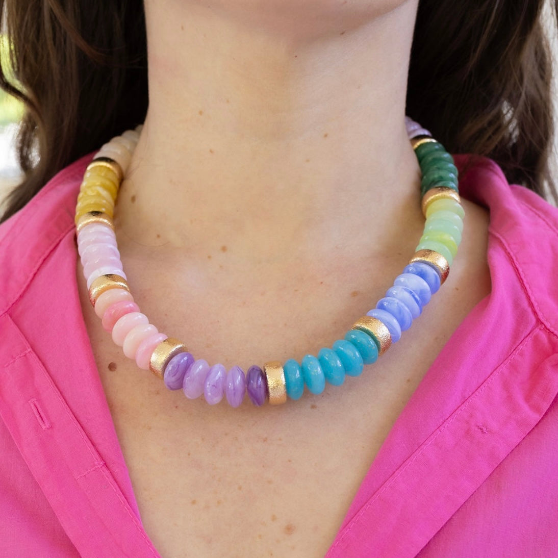 Colorful chunky beaded necklace worn by a person with a pink shirt