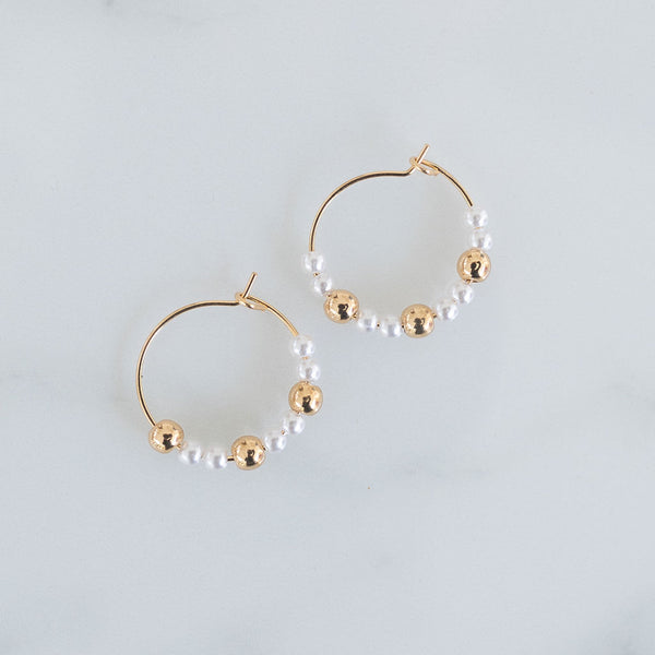 Picture of fine gold hoops threaded with pearl and gold beads. 