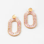 Pair of large oval pink beaded earrings with gold accents on a white background