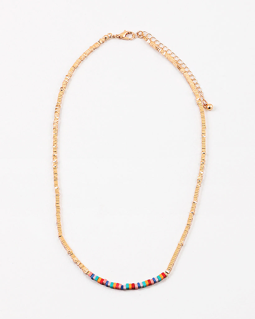 Dainty gold bead necklace with small red, yellow and turquoise beads at its center.