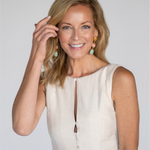 Woman wearing a white sleeveless top against a plain background
