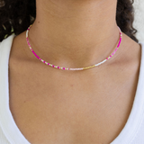 Dainty seed bead necklace made of white and pink beads with gold spacer beads