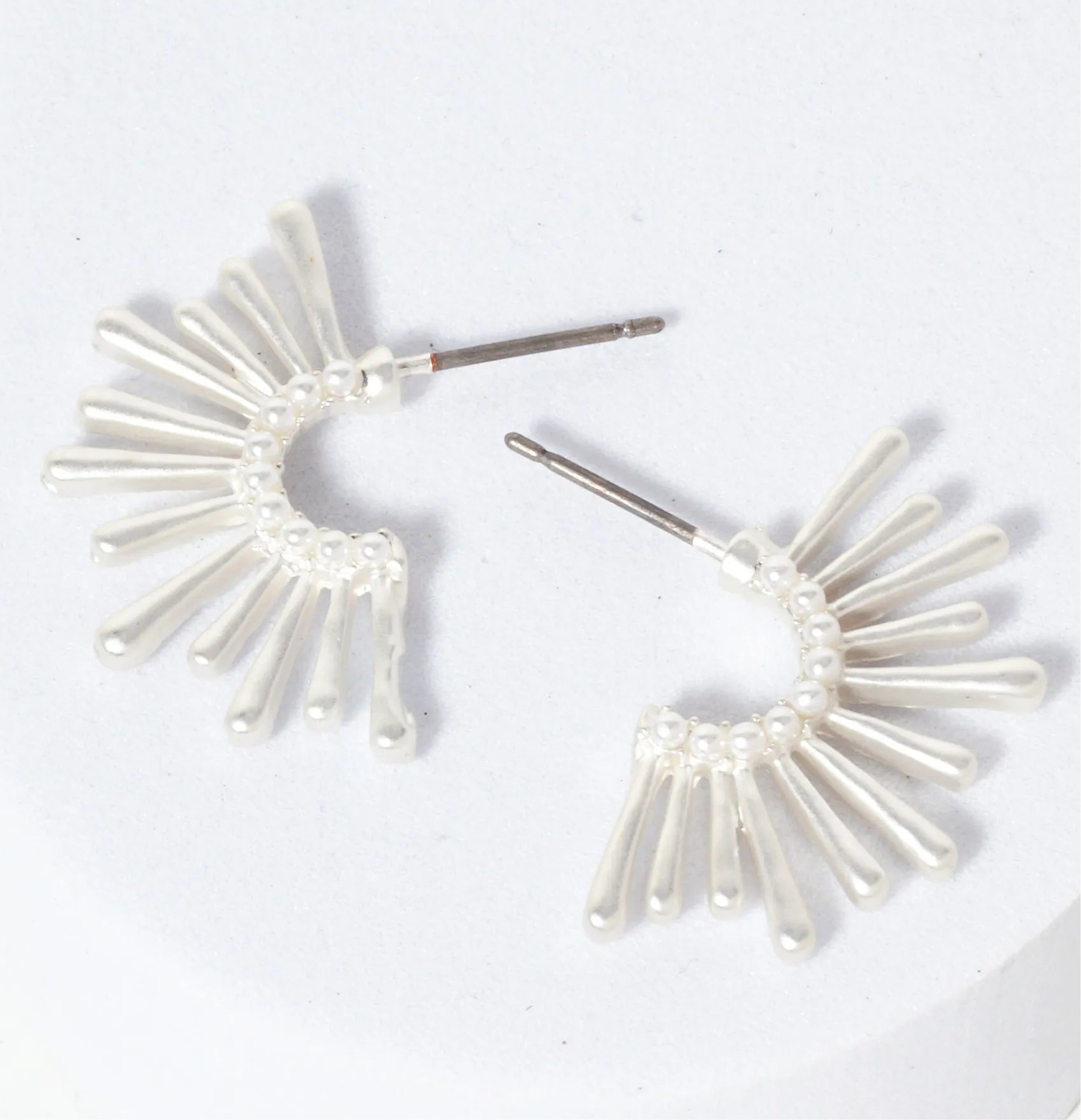 Set of silver starburst hoop earrings.