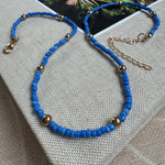 Picture of a dark blue seed bead necklace with accent gold beads 