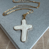 Gold chain with a large white cross.
