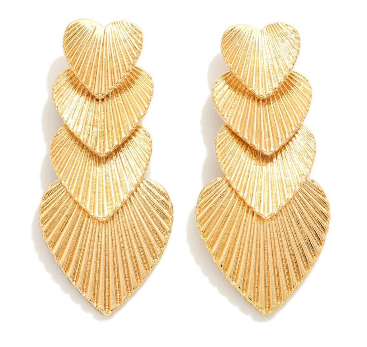 Gold layered heart-shaped earrings on a white background