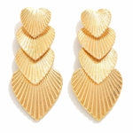 Gold layered heart-shaped earrings on a white background