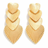 Gold layered heart-shaped earrings on a white background