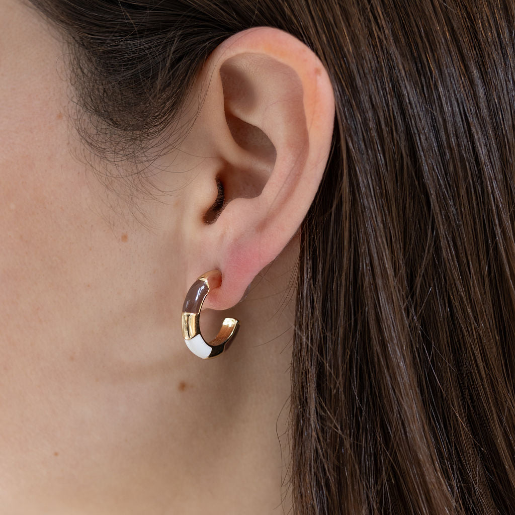 Picture of model wearing gold hoops with brown and white resin accents.