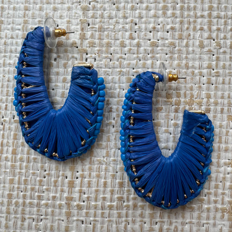 Natural blue material woven around gold hoops.