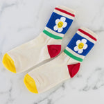 Colorful socks with retro flower primary color block design on a marble background