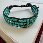 Woven bracelet with turquoise and silver black beads.