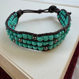 Woven bracelet with turquoise and silver black beads.