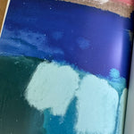 Close-up of a book page featuring a picture of a textured surface with blue, green, and white colors.