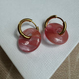 Gold hoops looped through large pink resin beads.